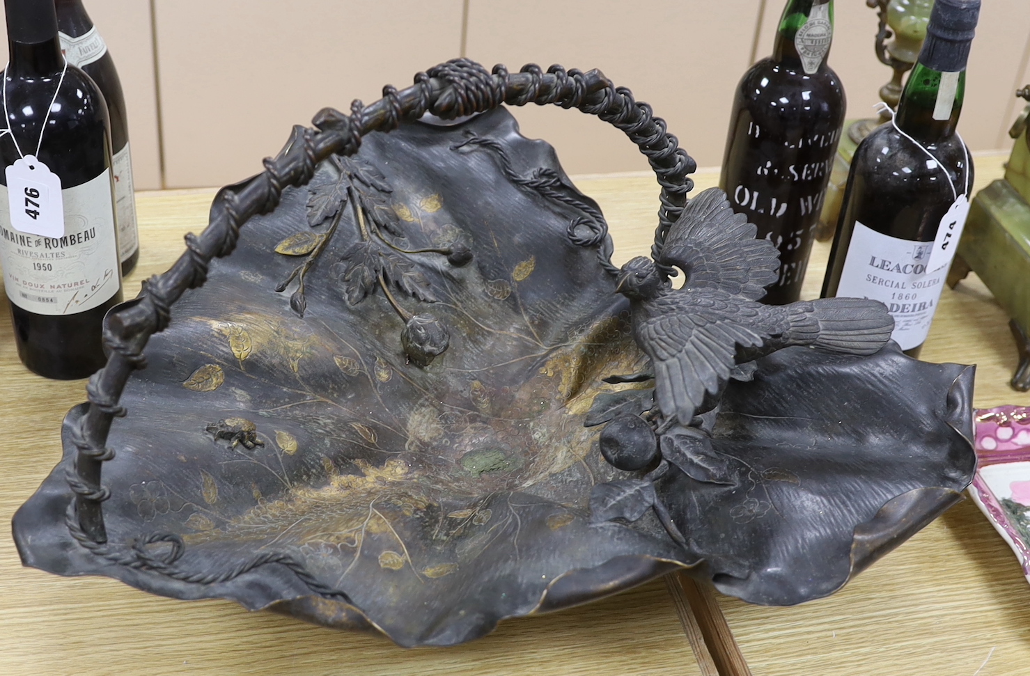 A Japanese bronze leaf centrepiece dish with a bird and flower surmount and handle, 53cm deep, 34cm high